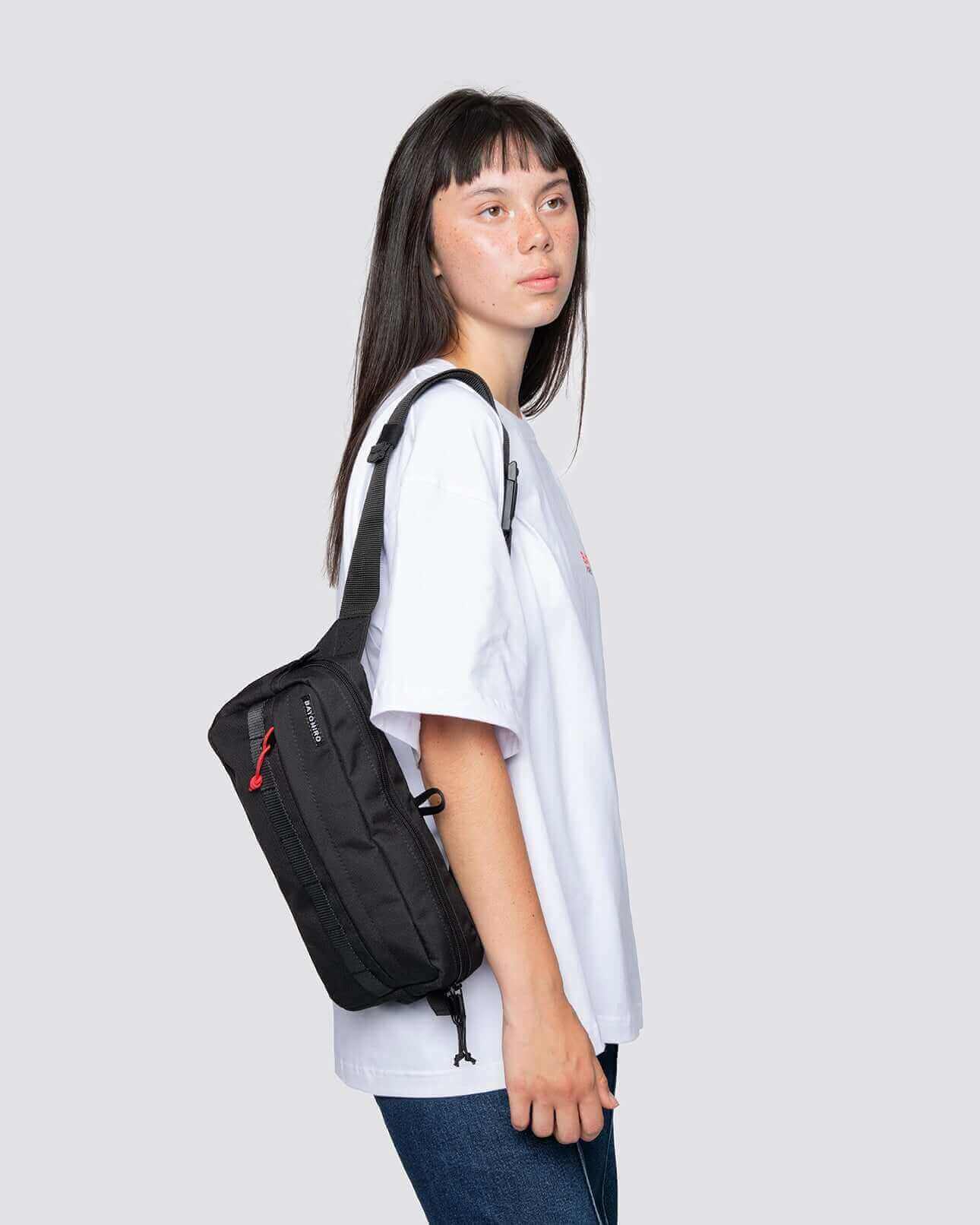 Stylish model showcasing Kai Blue Denim travel pouch worn as a crossbody bag, perfect for everyday use.