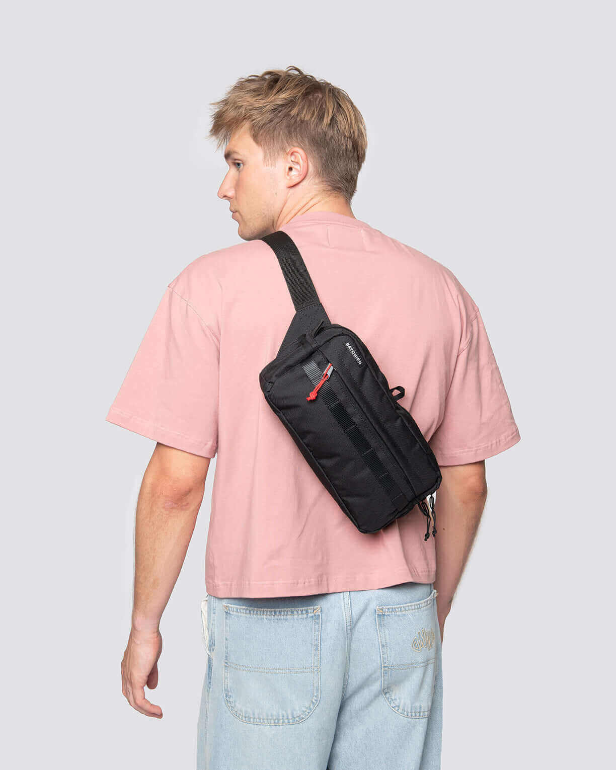 Model wearing Kai Blue Denim travel sling bag in black, showing versatile crossbody style and durable design.