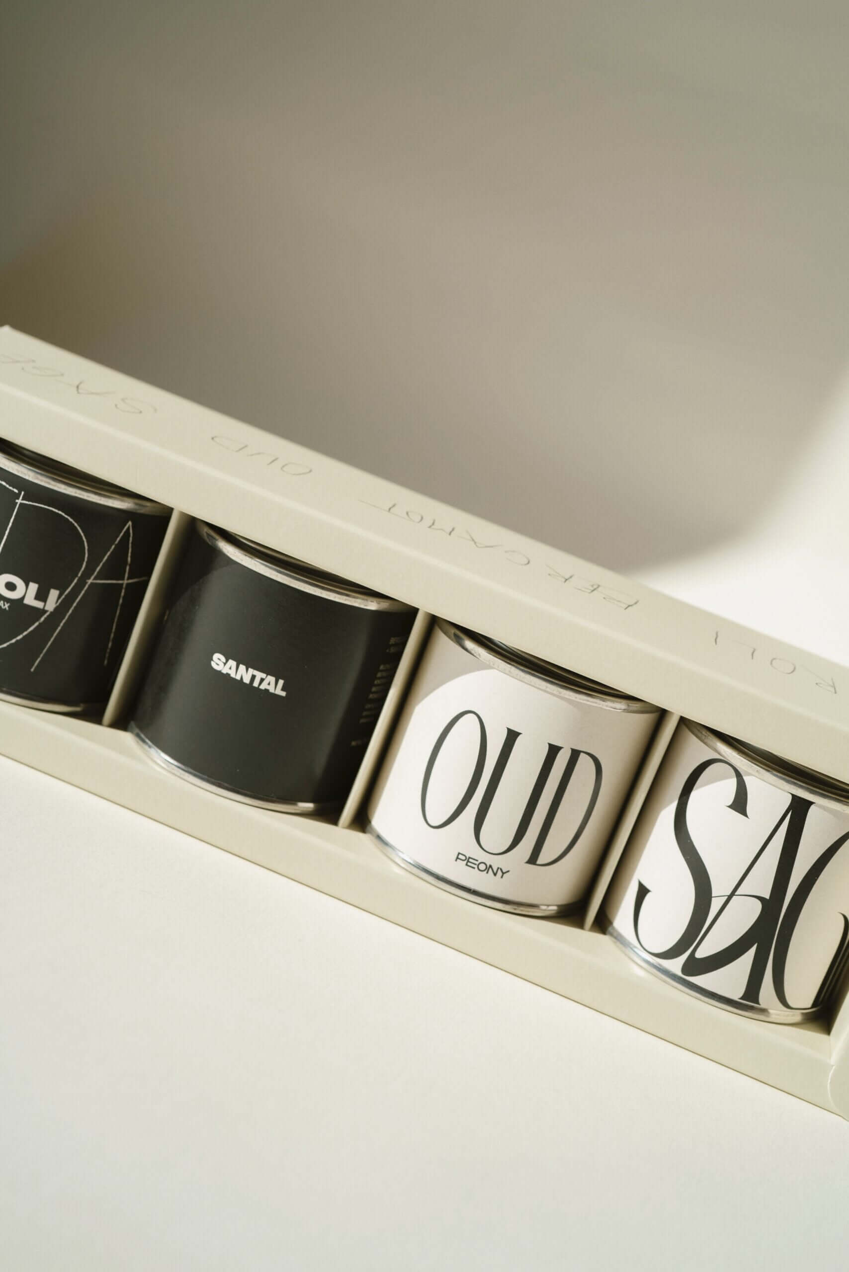MINI METAL TINS SET featuring luxury scented candles in stylish packaging with unique fragrance names.