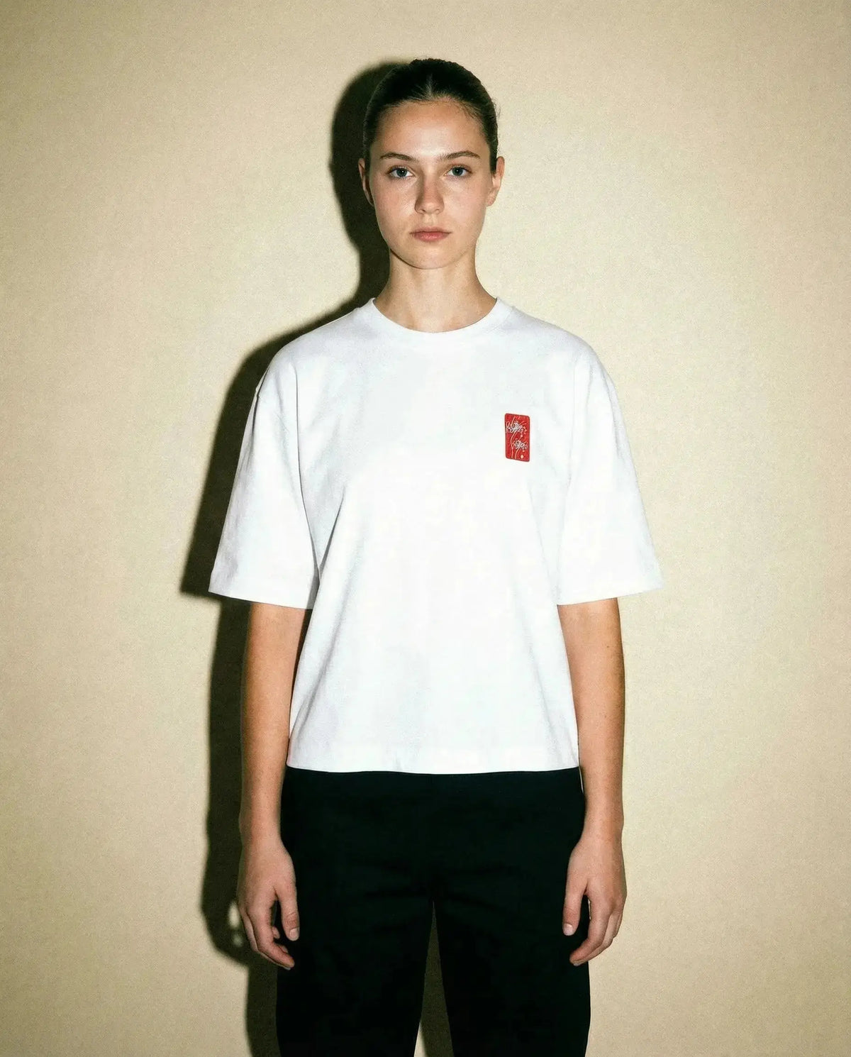 Spider Lily – Weißes, kurz geschnittenes Oversize-T-Shirt an einem Model vor neutralem Hintergrund.