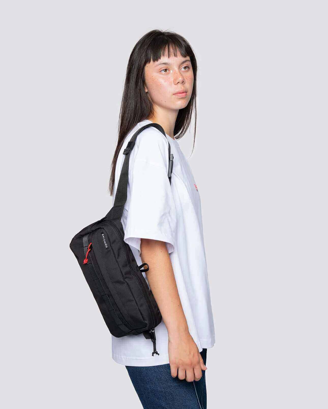 Model trägt eine schwarze crossbody reisetasche, ideal für Reisen und tägliche Verwendung.