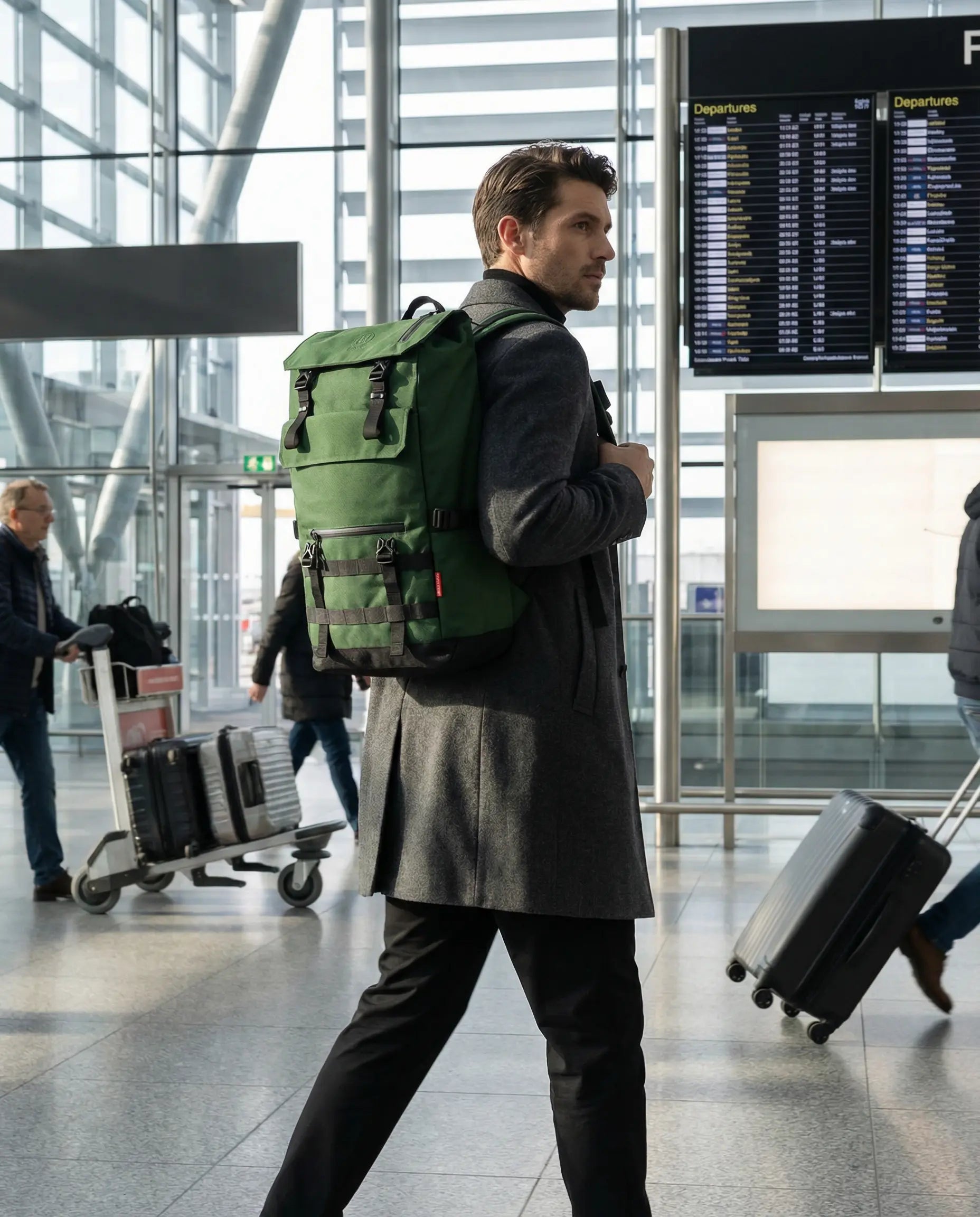 Man carrying Minato Premium 6.0 – Forest Green backpack at an airport terminal.
