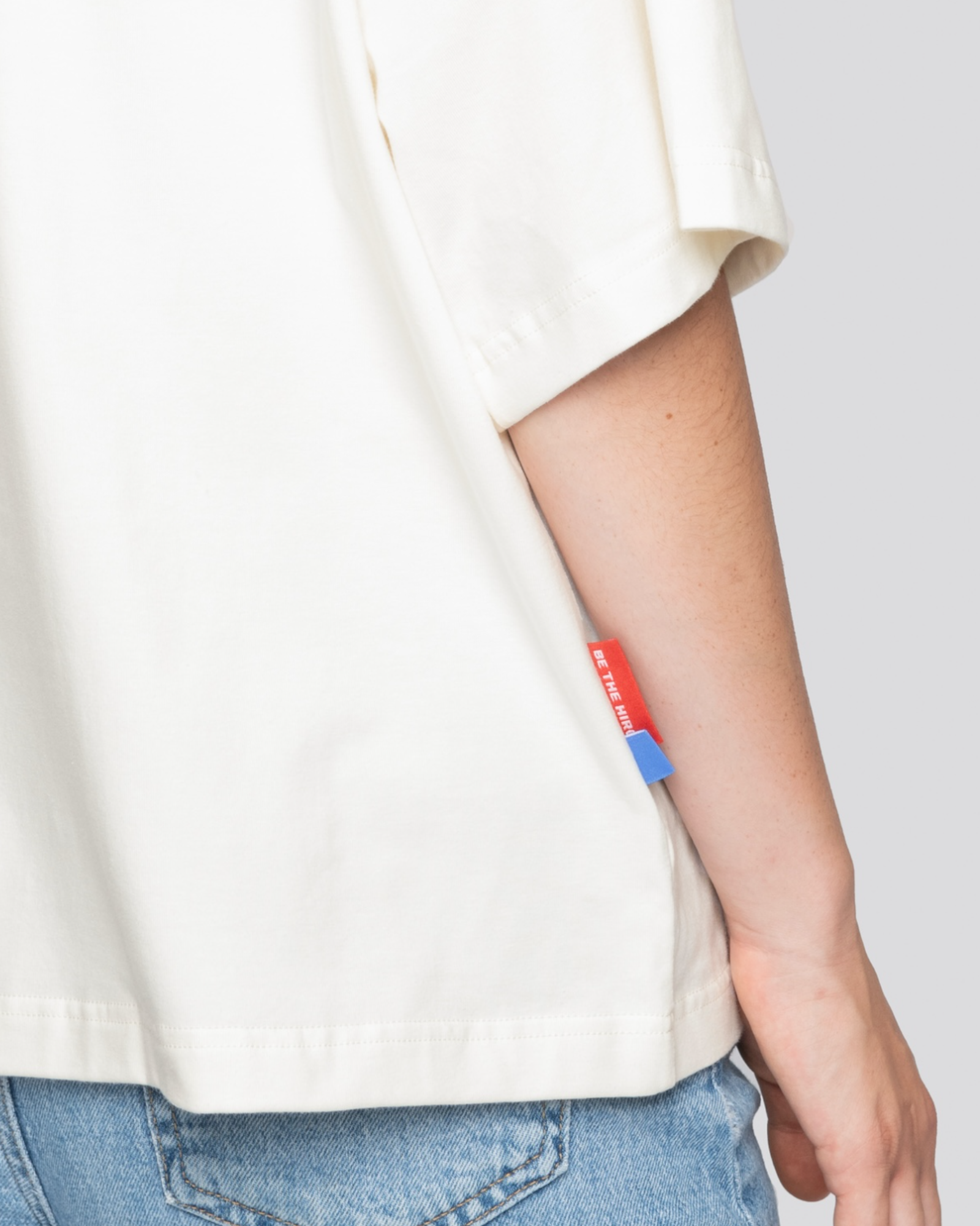 Cropped oversized cream tee by Batohiro, Czech-made, featuring blue and red tag detail.