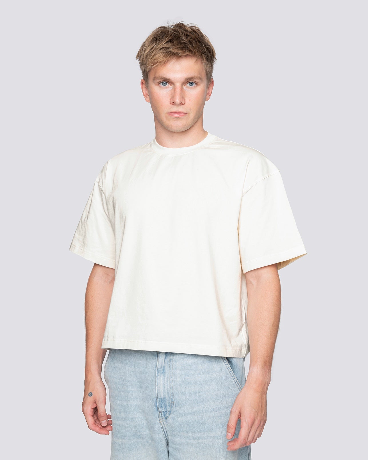 Cream cropped oversized tee modeled, handcrafted in Czech Republic, made of cotton and elastane blend for wrinkle resistance.