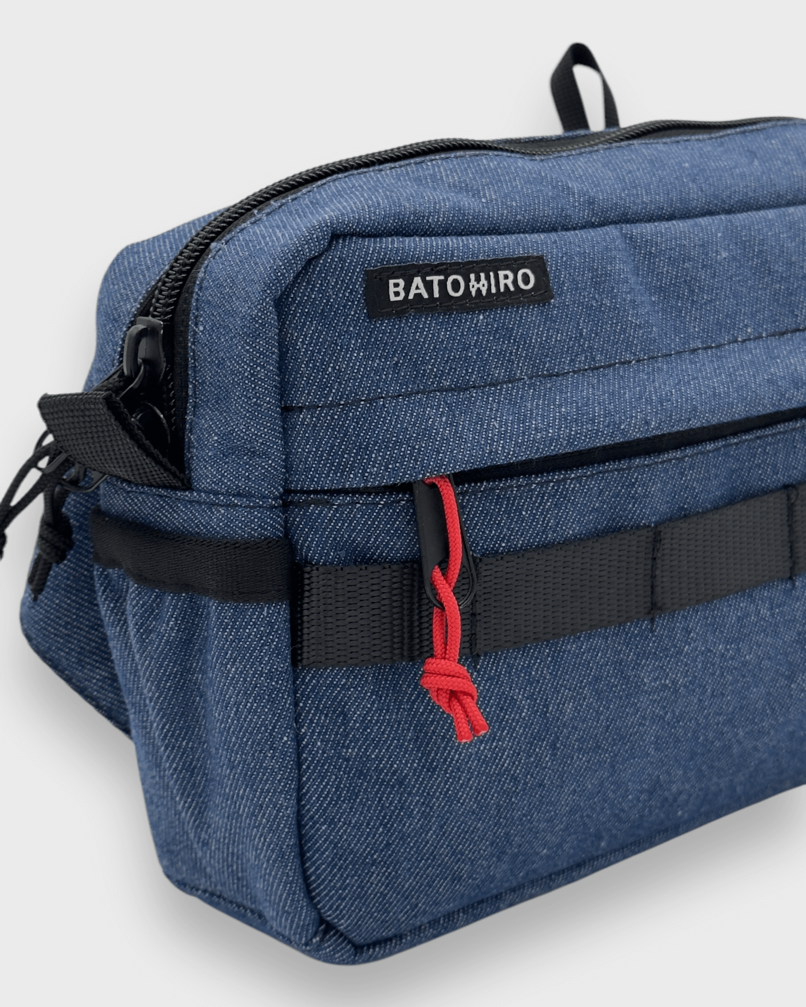 Stylish blue denim travel bag by Batohiro, featuring zippers and adjustable straps for versatility.